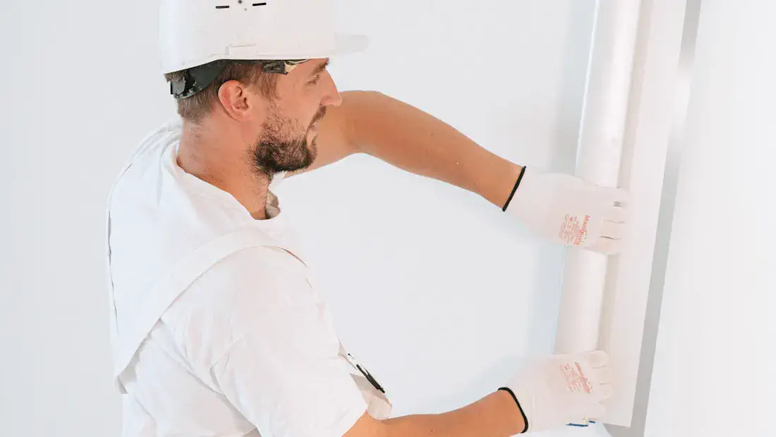 Instalador executando parede interna em drywall com acabamento limpo