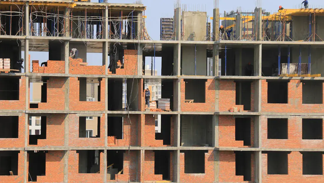 Estrutura predial em construção com equipe atuando na obra