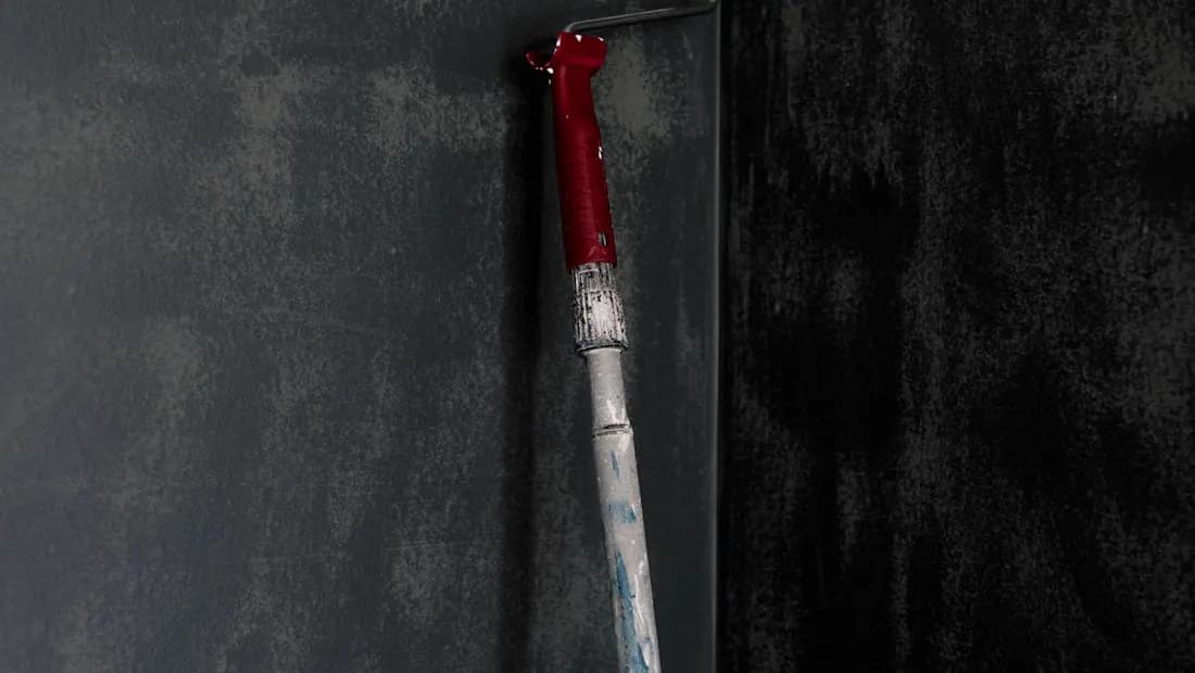 Ferramenta de pintura aplicando acabamento decorativo em parede escura